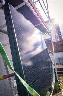 The picture shows a solar panel with the reflection of the sky and clouds, solar systems