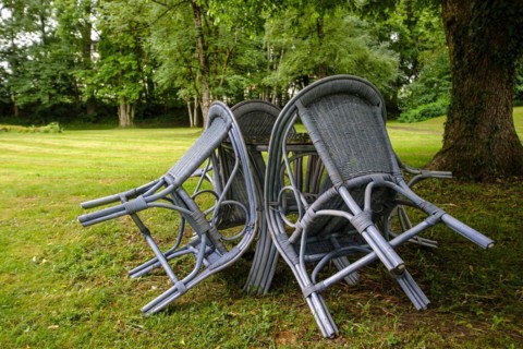 Four chairs are grouped around a table under a tree in a park, St George's Monastery, Isny im