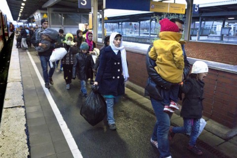 Refugees have arrived at Schoenefeld station on an IC train. They are then taken by bus to
