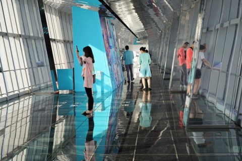 Viewing terrace, The Bottle Opener at 492 metres, visitors in front of a blue exhibition wall on a
