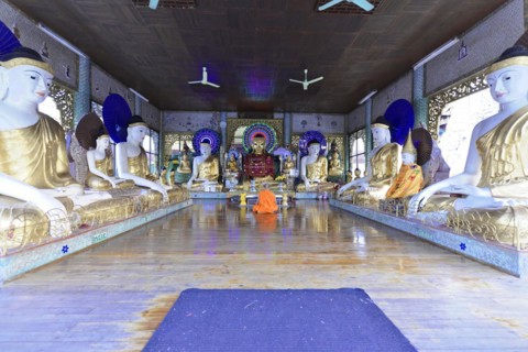 Shwedagon Pagoda, Yangon, Myanmar, Asia, A monk meditates between golden Buddha statues in a