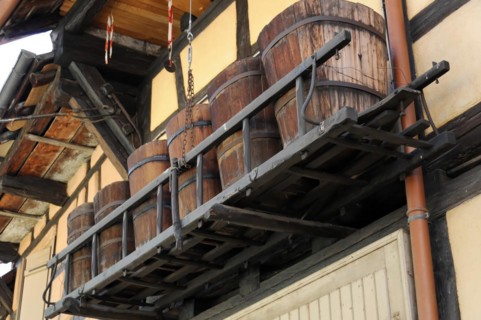 Eguisheim, Alsace, France, Europe, Wooden barrels stored on a beam on the outside of a