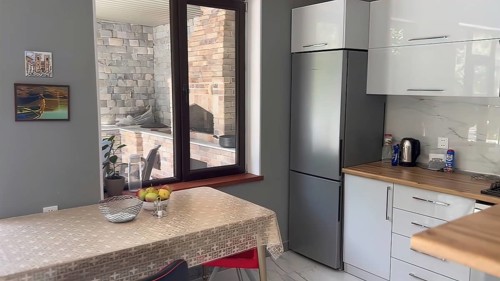 Interior of a modern kitchen with granite countertop and grey wall