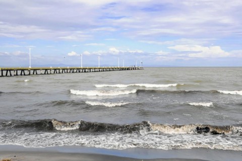 Granada, Nicaragua, Calm waves of Lake Nicaragua meet a long pier under a cloudy sky, Central