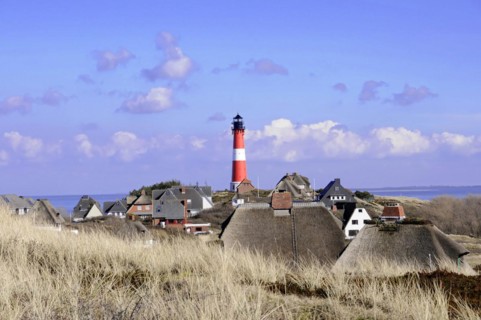 Lighthouse, Hoernum, Sylt, North Frisian Island, lighthouse rises behind a settlement with thatched