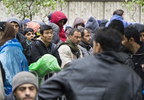 Syrian refugees wait for their registration in cold and wet weather at the Berlin State Office for