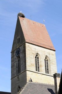 Eguisheim, Alsace, France, Europe, A church tower with a stork's nest on top under a clear blue