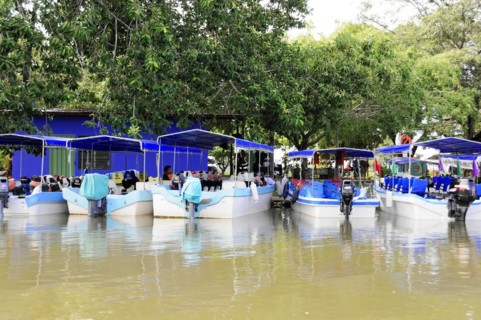 Granada, Nicaragua, Boats on Lake Nicaragua with market stalls and customers under colourful