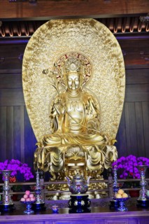 Jade Buddha Temple, Shanghai, Golden Buddha statue on an altar surrounded by pretty flowers,