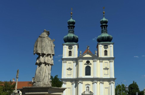 Double-tower facade of the Basilica of the Nativity of the Virgin Mary with Marian column, Roman