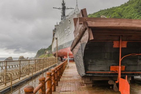Aft and rudder of wooden boat and exterior of South Korean battleship on display in Unification