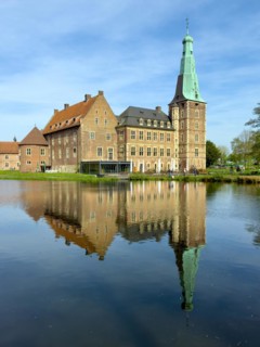 View over moat to historic moated castle from Renaissance Raesfeld Castle reflected in moat in