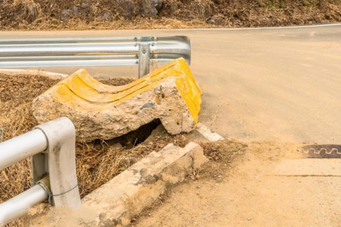 End buttress of street curb broken off and laying on ground at intersection in countryside in South