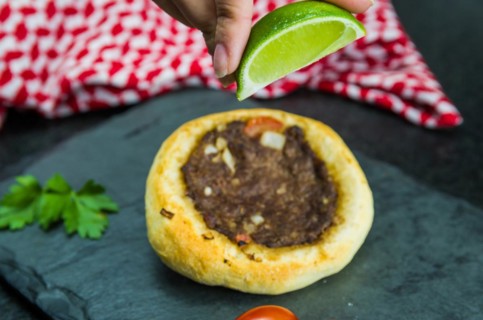 Delicious Lebanese (Arabic) food, squeezing lemon into legitimate sfihas on a black granite