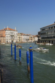 Blue mooring posts and water taxis on Grand canal with Renaissance architectural style residential