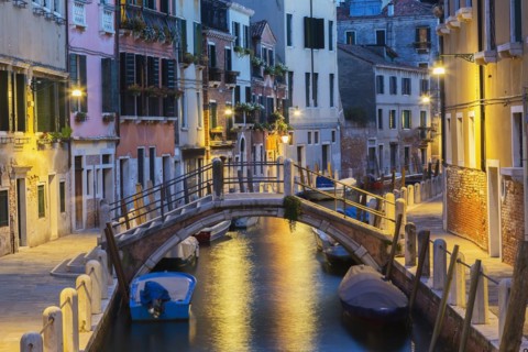 Moored boats and footbridge over Rio de la Toletta Canal with old architectural style residential