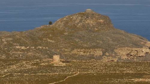 Ruins of a windmill, Hilly landscape with historical ruins and a path through the grass, Lindos,