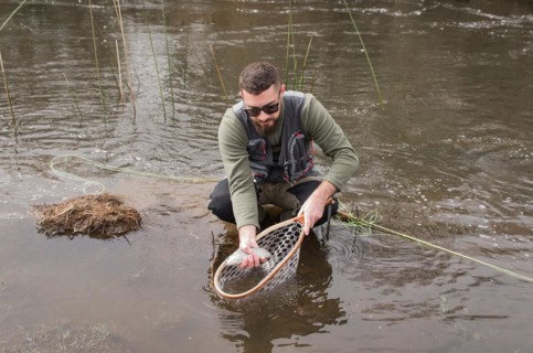 Fisherman fly fishing rainbow trout on mountain in beautiful scenery