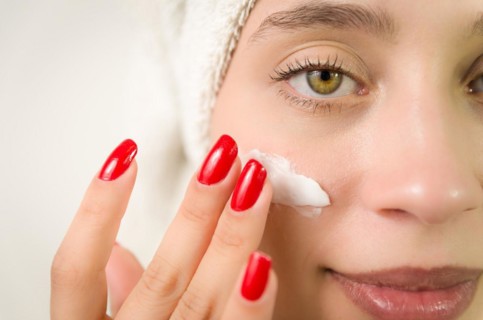 Hydration. Cream smear. Beuaty close up portrait of young woman with a healthy glowing skin is