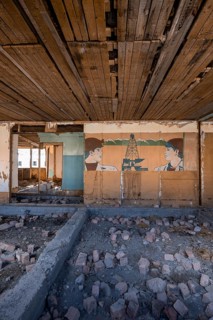Destroyed abandoned classroom of the old school, wall painting with Soviet miners, ghost town,