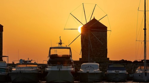 Windmill and boats silhouetted against a sunrise backdrop, twilight, Mandraki Oat, Rhodes,