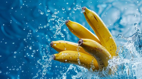 A bunch of yellow fresh bananas immersed in water and produce splash, AI generated