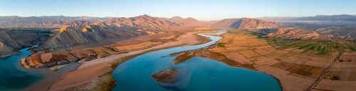 Naryn River between mountains and fields, at Toktogul Reservoir at sunset, aerial view, Kyrgyzstan,
