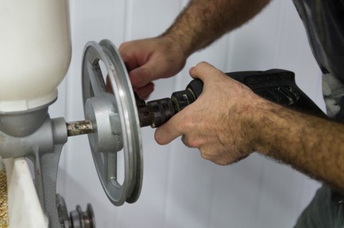 Homebrewer setting up a malt mill to grind with the aid of a drill