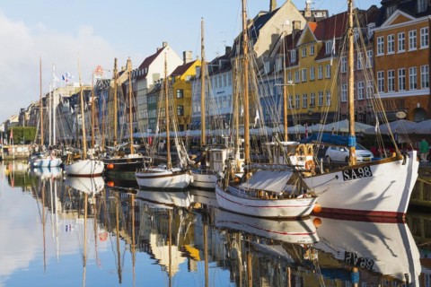 Moored sailboats and colourful 17th century apartment buildings and houses along the Nyhavn canal,