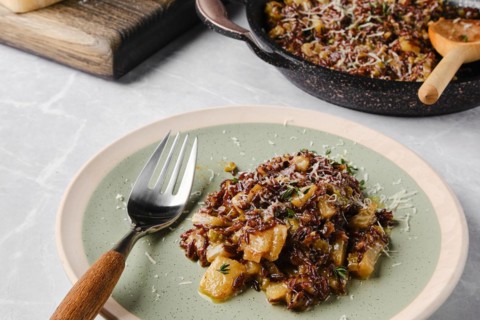 Risotto with pink rice, pear and blue cheese served on a table