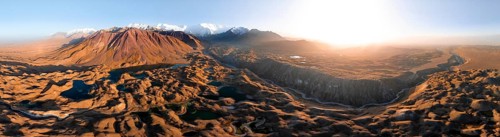 Atmospheric aerial view, high mountain landscape with glacier moraines and mountain lakes, behind