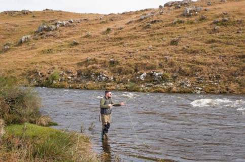Fisherman fly fishing rainbow trout on mountain in beautiful scenery