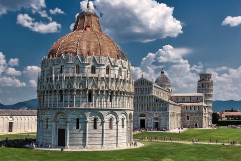 The Cathedral of Santa Maria Assunta and Baptistery with the Leaning Tower of Pisa under a blue sky