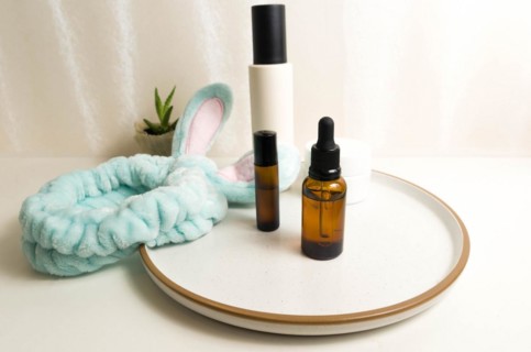 Cosmetic packaging. Set of different cosmetics on plate with decoration and bunny headband