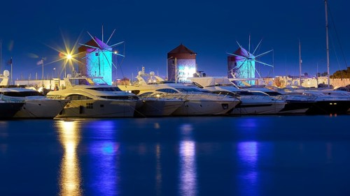 Marina with illuminated windmills reflected in the water during the blue hour, twilight, Mandraki