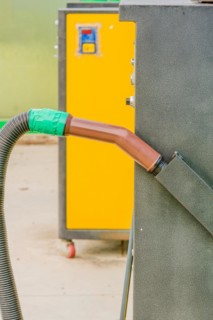 Brown vacuum cleaner handle with hose attached with green duct tape at gas station car wash in