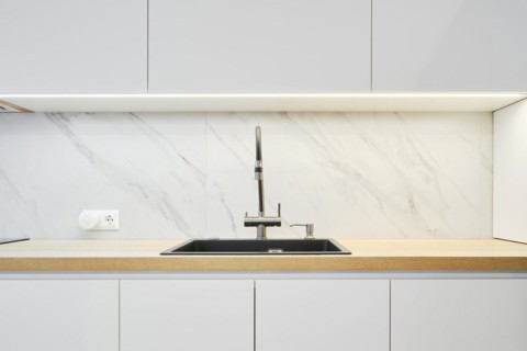 Water tap and sink in a modern bright kitchen