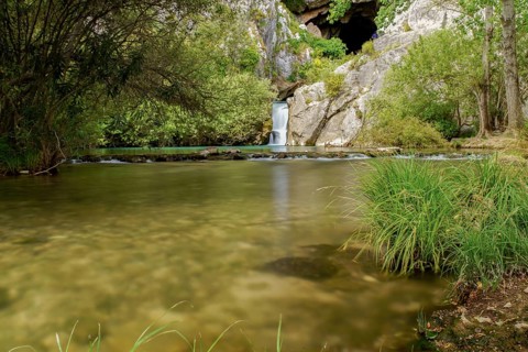 Waterfall of a mountain river with lush vegetation silk effect long exposure photography