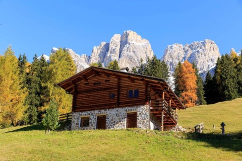 Rustic alpine hut against a backdrop of rugged mountains in autumn, Italy, Alto Adige, Bolzano