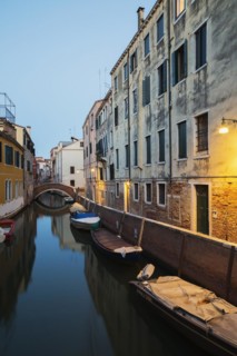 Moored boats and footbridge over Rio de la Toletta Canal with old architectural style residential