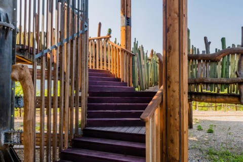 Wooden support columns and stairway going up to observation deck of tower in mountainside public