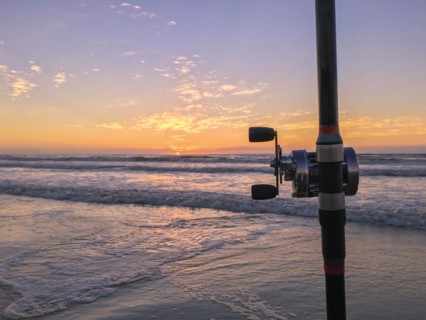 Fishing rod on beach at sunset, surfing cast