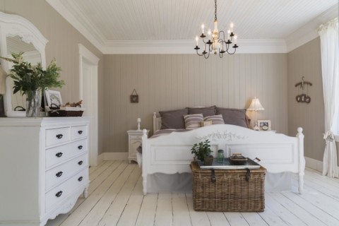 King size bed with light brown and beige striped bedspread, white painted wooden headboard and