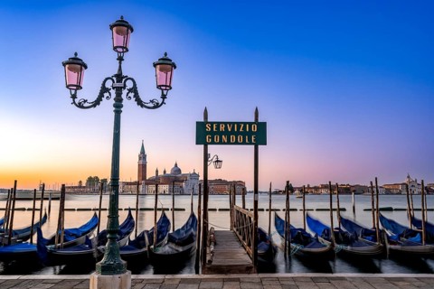 Venetian gondolas, boat dock with Servizio Gondole sign at St Mark's Square, San Giorgio Maggiore