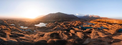 Atmospheric aerial view, high mountain landscape with glacier moraines and mountain lakes, behind