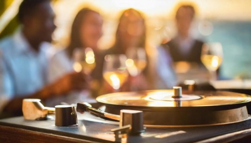 Friends enjoy drinks vinyl record playing together in cozy setting at sunset, bokeh effect ai