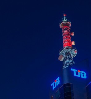 Communication array lit up with red lights on roof of TJB tower at blue hour inDaejeon, South