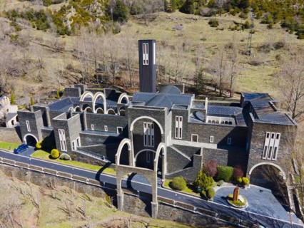 Aerial view of a historic monastery complex surrounded by greenery and Cypress trees, Santuario de