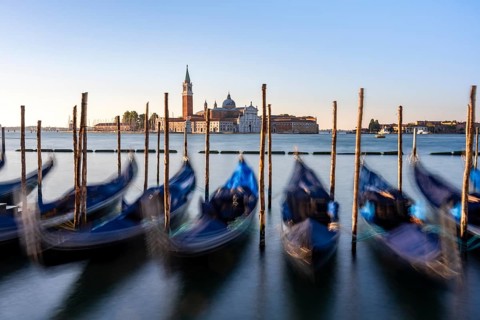 Venetian gondolas, boat dock at St Mark's Square, church of San Giorgio Maggiore in the background,