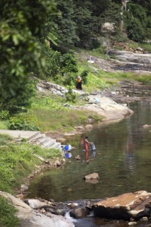 Indian woman washing clothes in the Periyar River, Mundakayam, Kerala, India, Asia